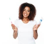 woman holds toothpaste